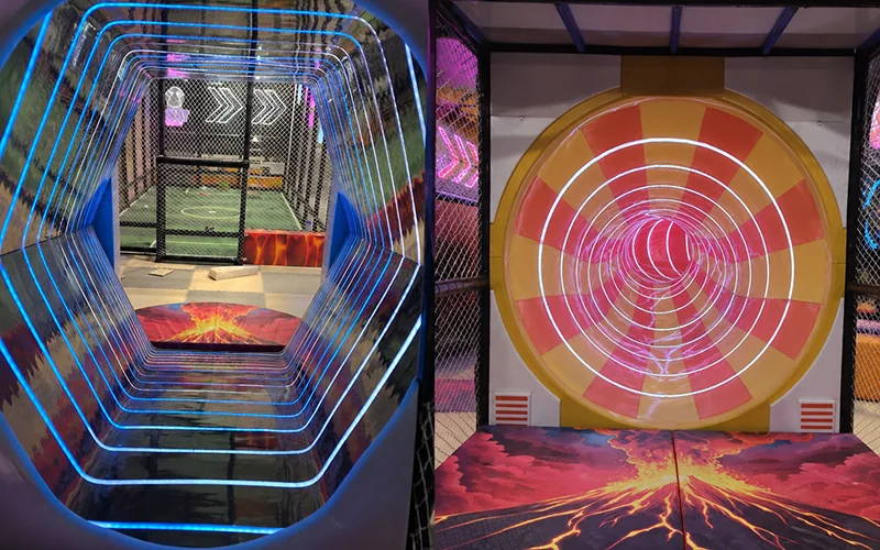 Interactive slide with lighting effects inside a futuristic indoor playground in Alicante, Spain, showing two illuminated slide entrances with soft landing protection.