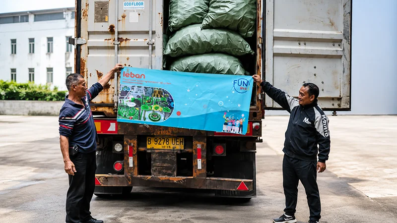 Lebanplay indoor playground factory staff holding a banner in front of a shipping container