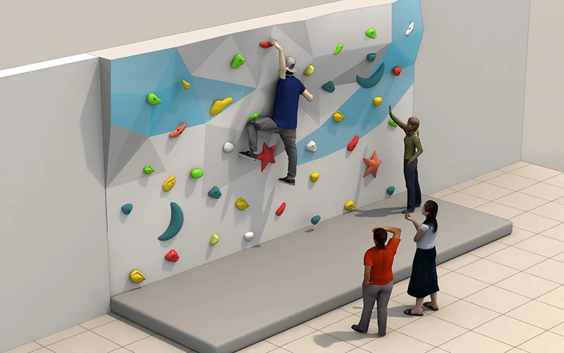 Modular indoor bouldering wall featuring colorful climbing holds and a safety crash pad, designed to maximize climbing area.