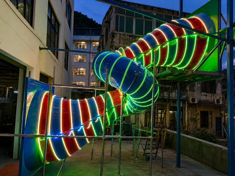 Irregular wormhole tube slide for indoor playground with neon LED lighting, commercial custom playground equipment manufactured by Lebanplay